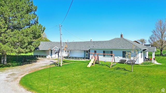 1317 S 400 E, Trenton, UT 84338 - back of house featuring a lawn, driveway, and a chimney