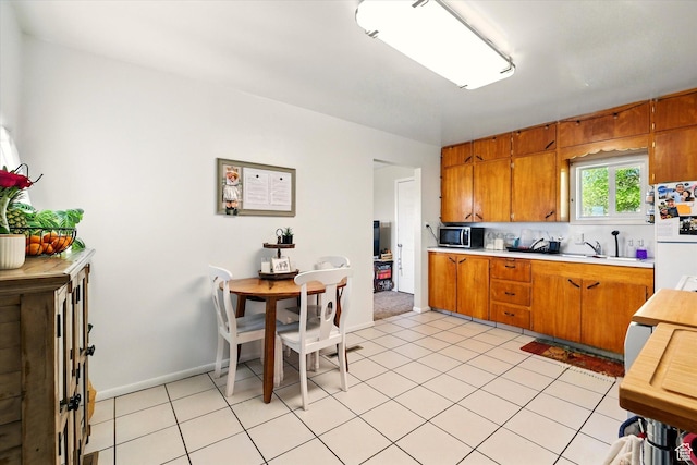 1317 S 400 E, Trenton, UT 84338 - kitchen featuring freestanding refrigerator, stainless steel microwave, light countertops, brown cabinets, and a sink