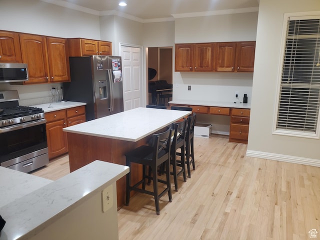 22 Snowstar Ln, Sandy, UT 84092 - kitchen featuring stainless steel appliances, ornamental molding, light countertops, a breakfast bar area, and brown cabinetry