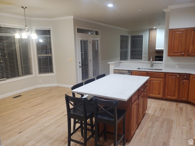 22 Snowstar Ln, Sandy, UT 84092 - kitchen with a sink, light wood-style floors, light countertops, a breakfast bar, and crown molding