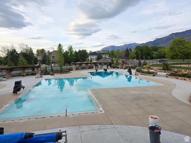 22 Snowstar Ln, Sandy, UT 84092 - community pool with fence, a mountain view, and a patio area