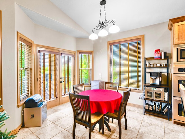 dining space with vaulted ceiling, light tile patterned floors, and baseboards