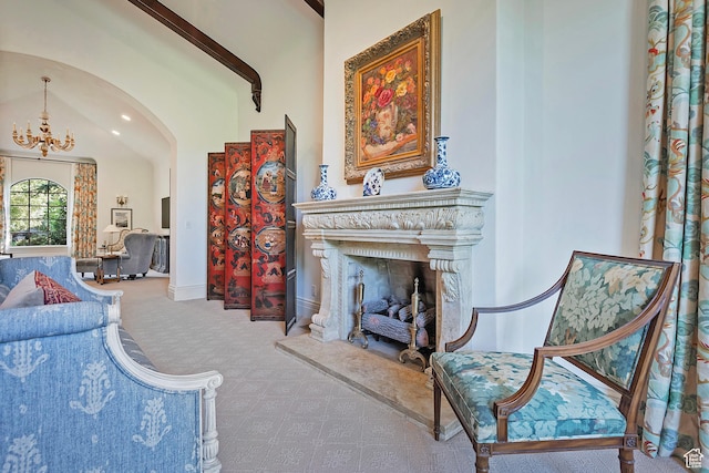 sitting room featuring carpet floors, arched walkways, a chandelier, baseboards, and a high end fireplace