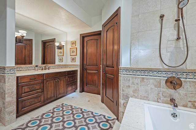 bathroom featuring a tub, vanity, tile walls, and tile patterned flooring