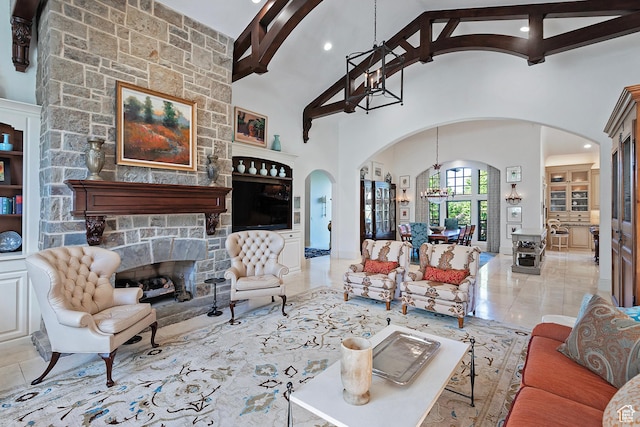 living room with arched walkways, beamed ceiling, high vaulted ceiling, a stone fireplace, and recessed lighting
