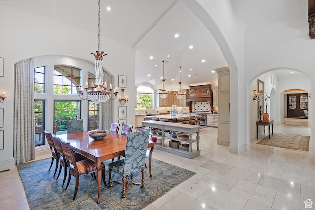 dining space featuring a chandelier, high vaulted ceiling, recessed lighting, arched walkways, and baseboards