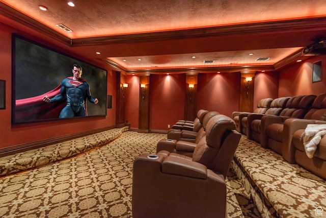 carpeted home theater room featuring ornamental molding, a tray ceiling, baseboards, and recessed lighting