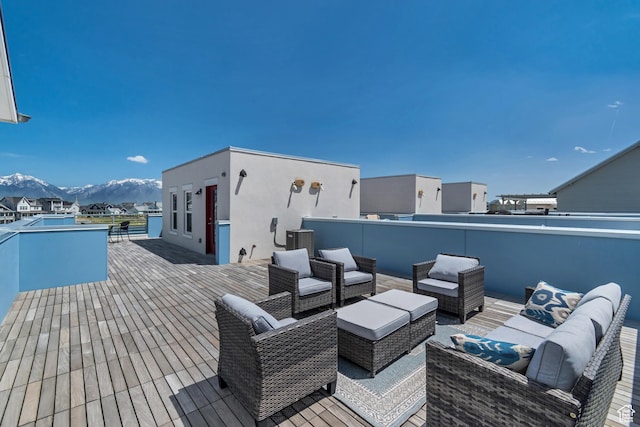 wooden terrace with an outdoor hangout area, a mountain view, and central AC