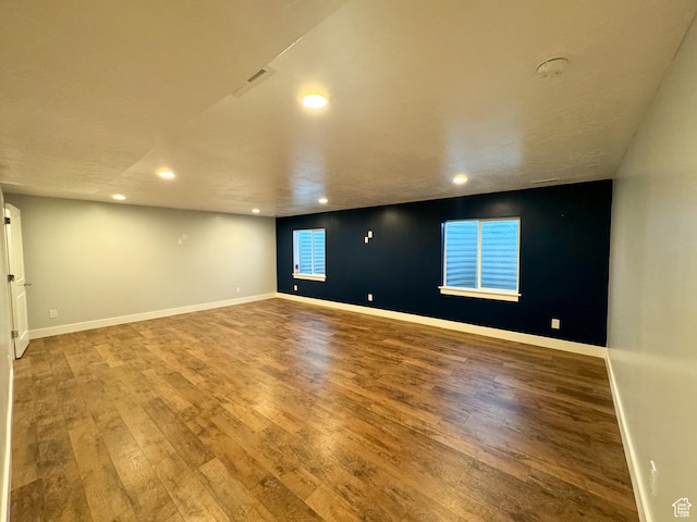 spare room featuring recessed lighting, wood finished floors, and baseboards