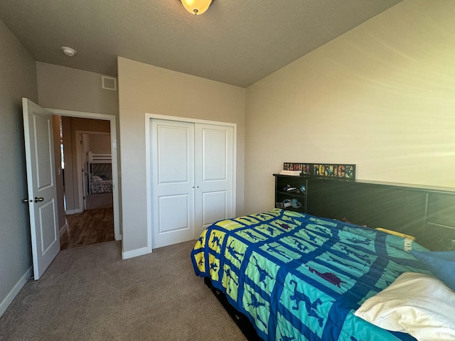 carpeted bedroom featuring a closet and baseboards