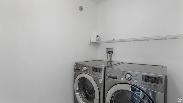 clothes washing area with washer and clothes dryer