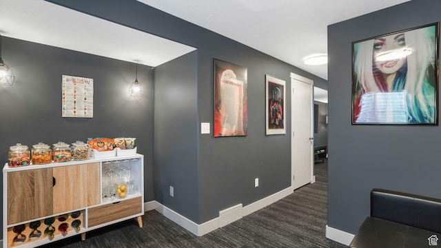 hallway featuring baseboards and wood finished floors