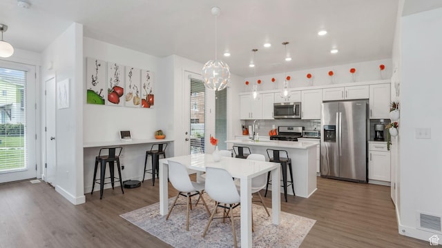 dining space featuring wood finished floors, a chandelier, baseboards, and recessed lighting