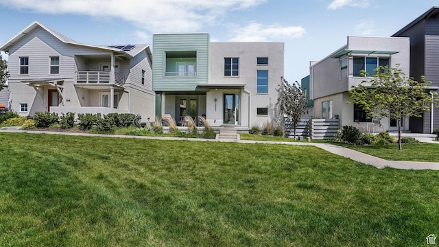 view of front of house with stucco siding and a front lawn