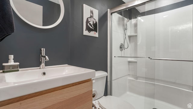 bathroom featuring a shower stall, toilet, and vanity