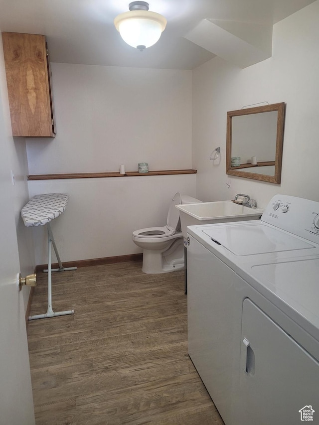 washroom featuring washing machine and clothes dryer, wood finished floors, and baseboards