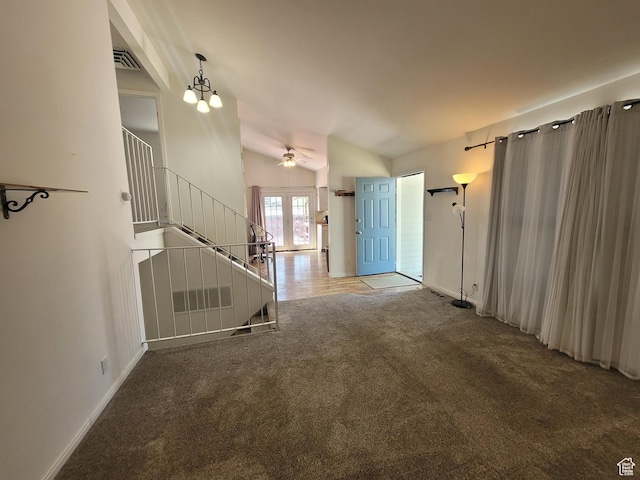 unfurnished living room featuring carpet floors, stairway, a ceiling fan, lofted ceiling, and baseboards