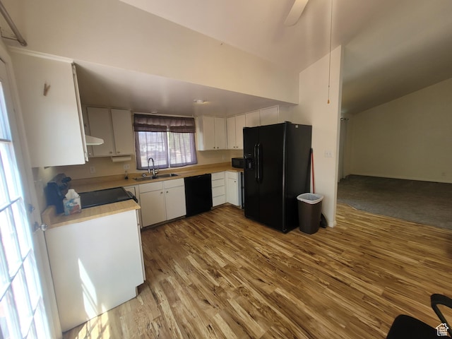 kitchen featuring black appliances, a sink, wood finished floors, light countertops, and white cabinets