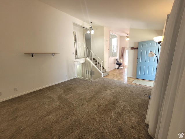 unfurnished living room featuring carpet floors, baseboards, and stairway