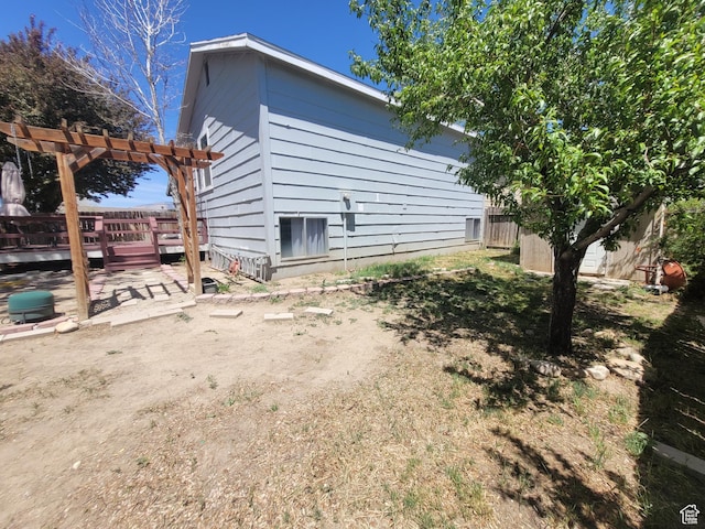 view of side of property with a pergola and a deck