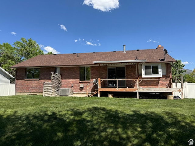 rear view of property featuring brick siding, cooling unit, a deck, and a shingled roof