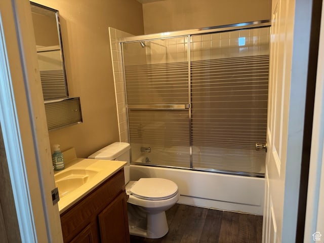 full bathroom with toilet, vanity, combined bath / shower with glass door, and wood finished floors