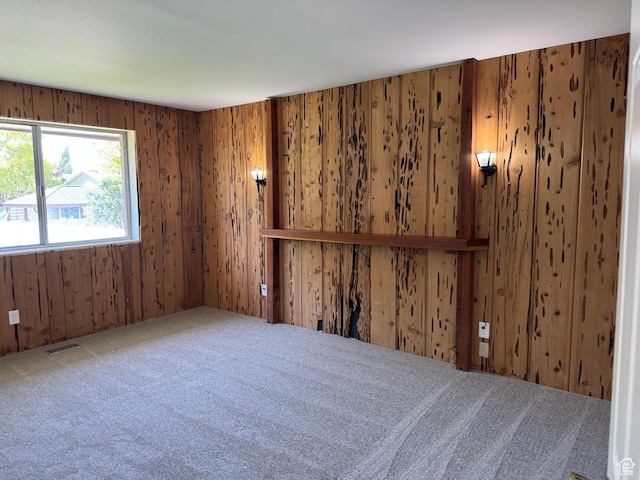 spare room with carpet and wooden walls