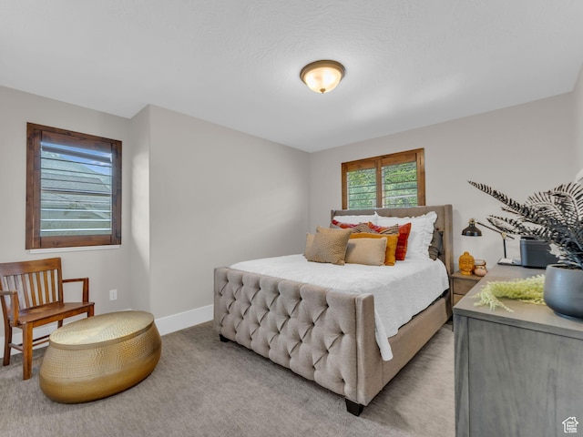 bedroom featuring light carpet and baseboards