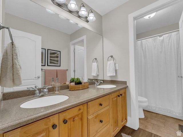 bathroom featuring double vanity, toilet, and curtained shower