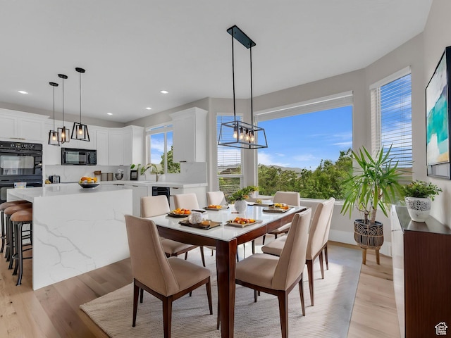 dining room featuring a chandelier, light wood-type flooring, and recessed lighting
