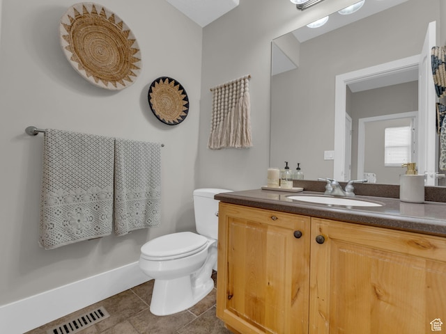 bathroom with toilet, tile patterned floors, and vanity