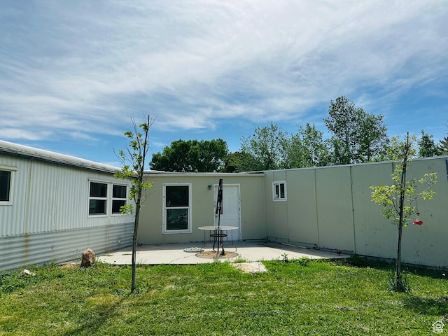 back of house with a patio area and a yard