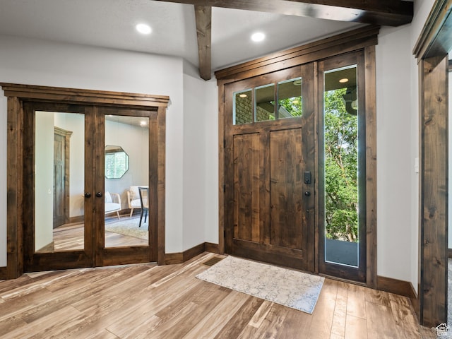 foyer with baseboards, french doors, light wood-type flooring, and recessed lighting