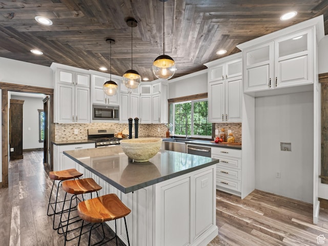 kitchen with stainless steel appliances, dark countertops, wooden ceiling, white cabinetry, and glass insert cabinets