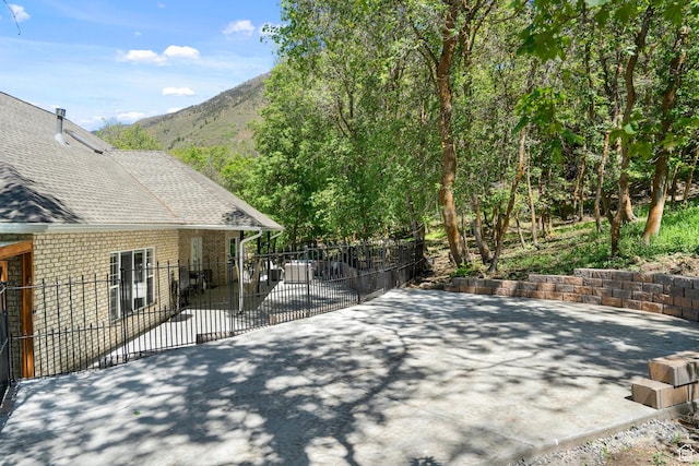 view of patio / terrace featuring fence and a mountain view