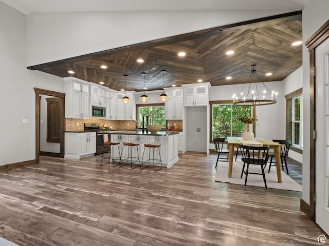 kitchen with appliances with stainless steel finishes, dark countertops, white cabinetry, decorative backsplash, and recessed lighting