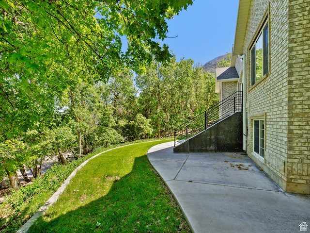 view of green lawn with a patio