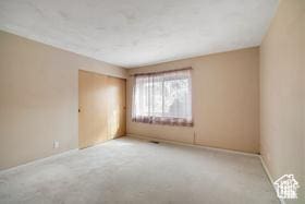 unfurnished room with carpet flooring and baseboards