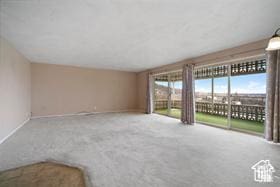 unfurnished living room featuring carpet and baseboards