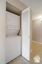 laundry room featuring stacked washer / drying machine
