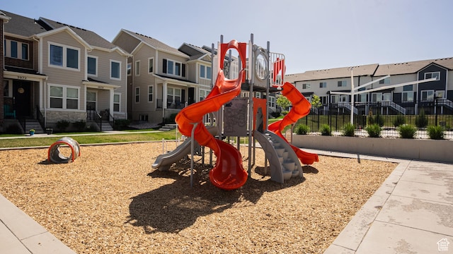 community jungle gym with a residential view and fence