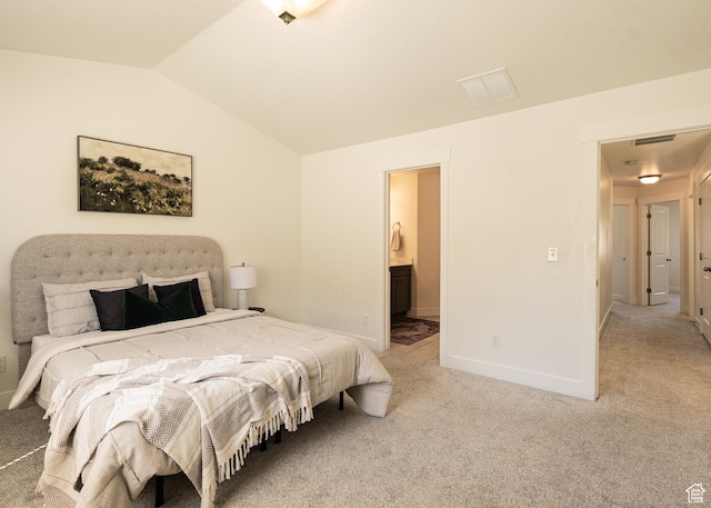 bedroom featuring vaulted ceiling, light carpet, baseboards, and connected bathroom