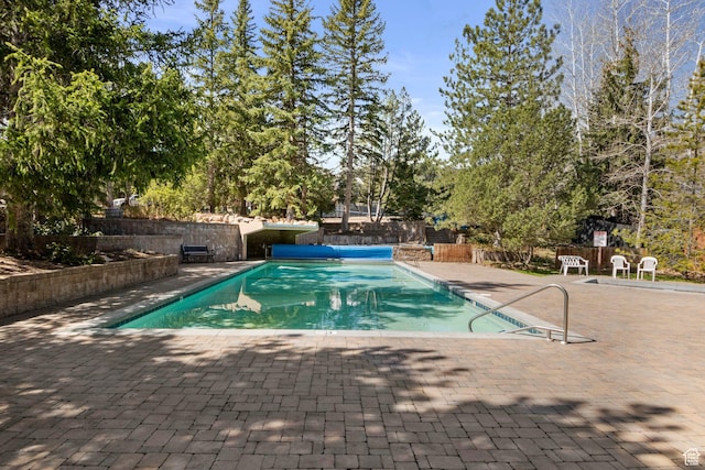 view of pool with a patio area and fence