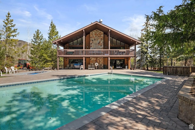 community pool with a patio area, a community hot tub, and fence