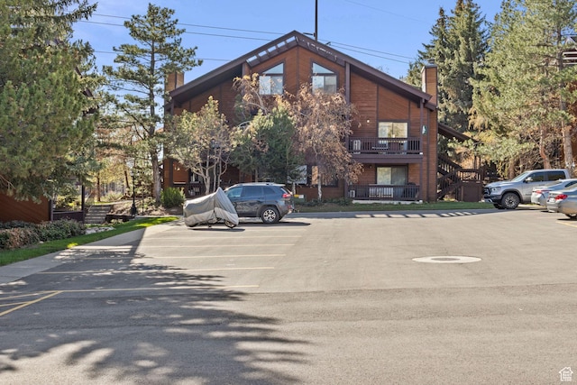 view of property featuring uncovered parking and stairway