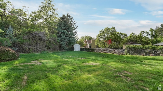 10804 S Lostwood Dr, Sandy, UT 84092 - view of green lawn with a storage unit and an outdoor structure