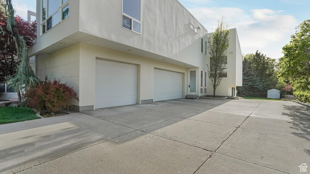 10804 S Lostwood Dr, Sandy, UT 84092 - view of side of property with an attached garage, stucco siding, and driveway