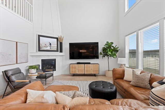 13741 S 3870 W, Riverton, UT 84065 - living room featuring a large fireplace, a towering ceiling, plenty of natural light, wood finished floors, and baseboards