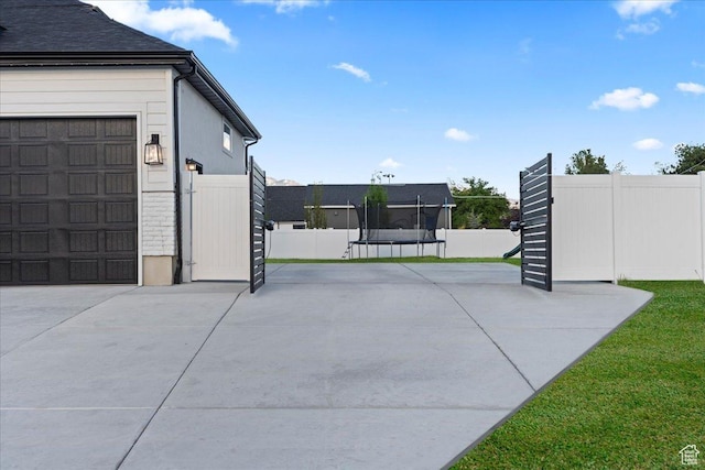 13741 S 3870 W, Riverton, UT 84065 - garage featuring a trampoline and concrete driveway