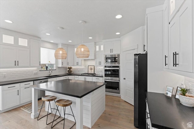 13741 S 3870 W, Riverton, UT 84065 - kitchen with dark countertops, stainless steel appliances, a sink, a breakfast bar area, and recessed lighting